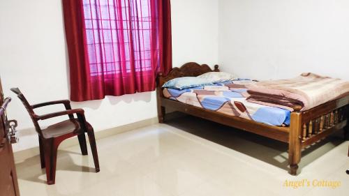 a bedroom with a bed and a chair in it at Angel's Cottage in Munnar