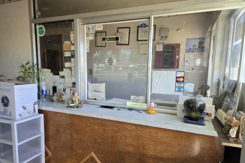 a store counter with a window with a laptop on it at Eagle Inn by Hotel O Richmond Midlothian Turnpike in Richmond