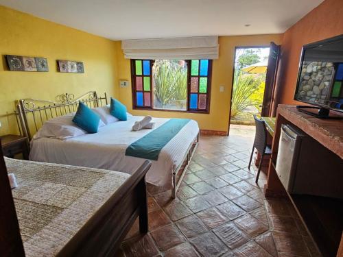 a bedroom with a bed and a tv and a window at La Primavera, casas campestres para familias, paisajes, tranquilidad, cerca al pueblo in Villa de Leyva