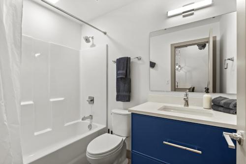a bathroom with a white toilet and a sink at Brick & Bed Riverfront Lofts, T 305 in Saint Louis