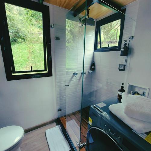 a bathroom with a glass shower and a toilet at La Tiny TINY HAUS in Bogotá