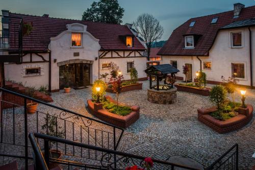 a large house with a courtyard with plants and lights at Dworek Galosa in Stronie Śląskie