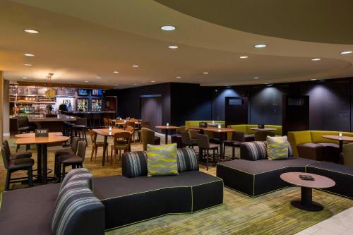 a restaurant with tables and chairs and a bar at Courtyard by Marriott Daytona Beach Speedway/Airport in Daytona Beach