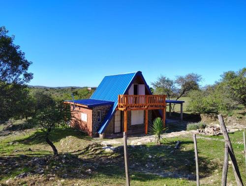 a cabin with a deck and a house at Angel Alpino Cabin in Cuesta Blanca