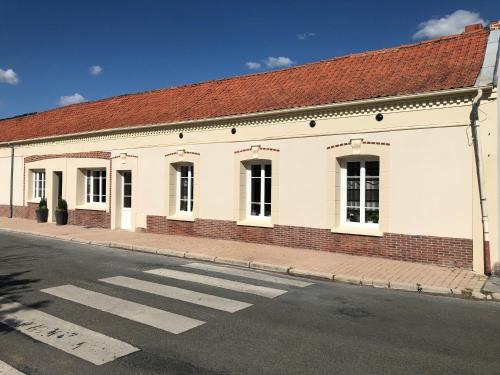 a white building with a red roof on a street at L'auberge fleurie in Heilly