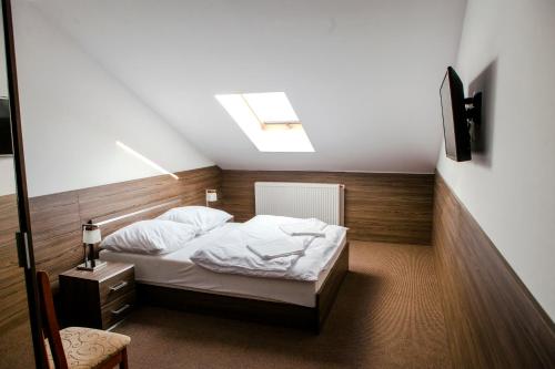 um quarto com uma cama e uma clarabóia em Motel Domowy Gościniec em Łomża