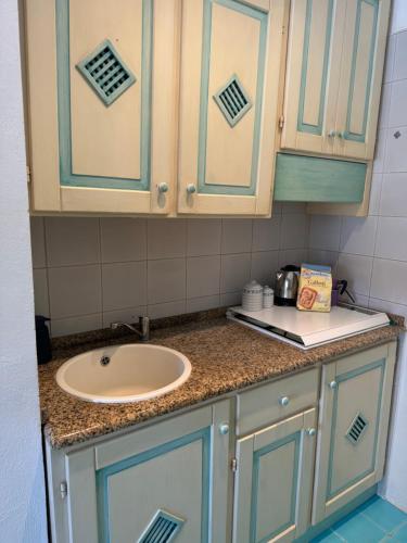 a bathroom counter with a sink and blue cabinets at Studio flat in Sardinia Costa Smeralda in Porto Rotondo