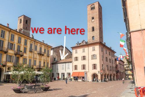 a city street with a sign that says we are here at Palazzo Ciravegna, Alba Duomo View in Alba