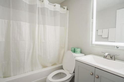 a white bathroom with a toilet and a sink at Thunderbird Motel in Savannah