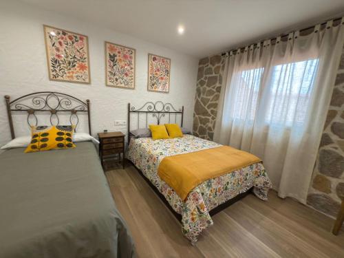 a bedroom with two beds and a window at Casa Rural Tomillo in Navalcán