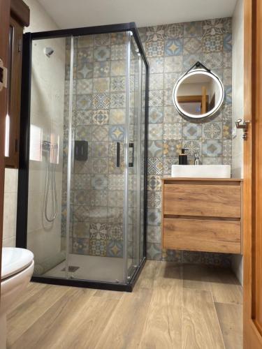a bathroom with a shower with a sink and a mirror at Casa Rural Tomillo in Navalcán