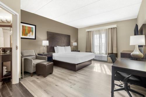 a hotel room with a bed and a chair at Best Western Kenner in Kenner