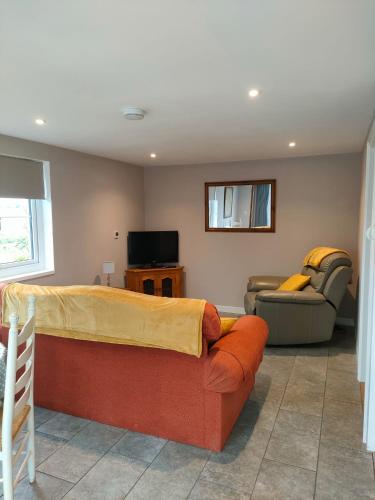 a living room with a bed and a couch at Townfield Lodge in Bury Saint Edmunds