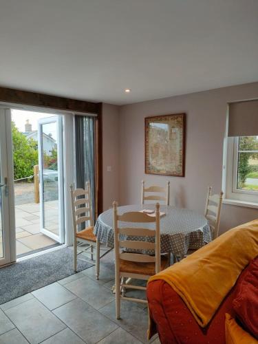 a dining room with a table and chairs and a bedroom at Townfield Lodge in Bury Saint Edmunds