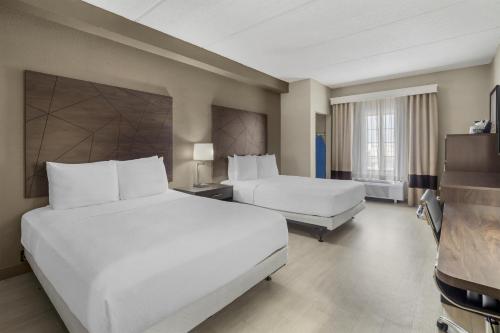 a hotel room with two beds and a television at Best Western Kenner in Kenner