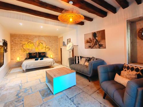 a living room with a bed and a couch and a table at L'écrin - Chablis - Homerepublique- Plein centre - Élégant - Parking à proximité in Chablis