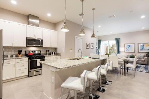 a kitchen with white cabinets and a large island at Fantastic Townhome 5min Disneyworld 134 in Orlando