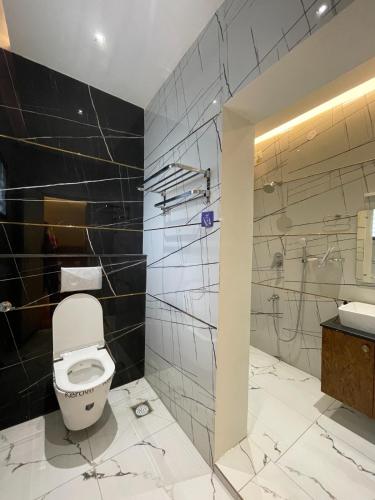 a bathroom with a white toilet and a sink at Suthanthira stay Inn in Dindigul