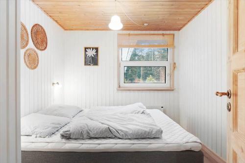 a bed in a white room with a window at TV1706-Bindslev-Uglevej-7 in Tversted