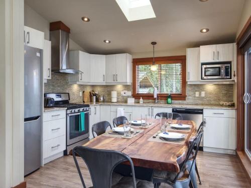 a kitchen with a wooden table with chairs around it at Going Coastal A - Oceanfront - Pet Friendly in Port Renfrew
