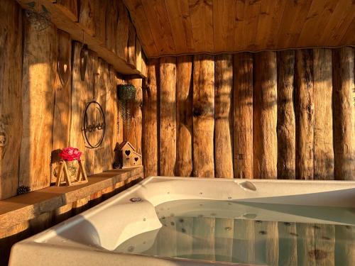a bath tub in a room with wooden walls at Coeur de Lodge spa privatif in Cramoisy