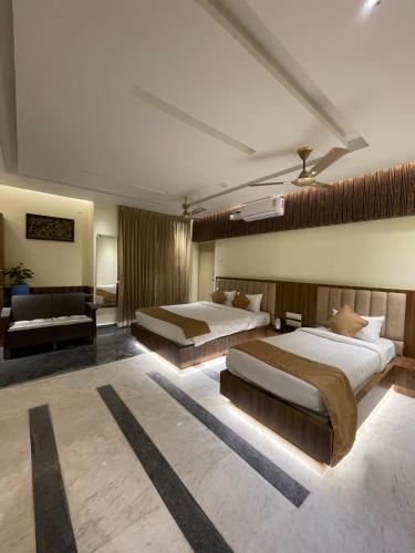 a hotel room with two beds and a couch at Suthanthira stay Inn in Dindigul