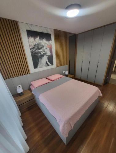 a bedroom with a large bed with pink pillows at Master apartman in Podgorica