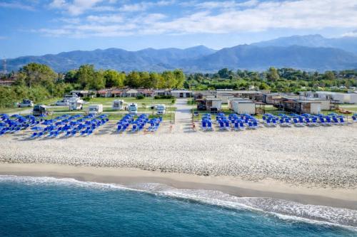 an aerial view of a beach with chairs and the water at The Beach Camping Village in Marina di Carrara
