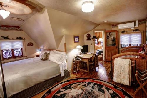 a bedroom with a bed and a desk in a room at The Queen, A Victorian Bed & Breakfast in Bellefonte