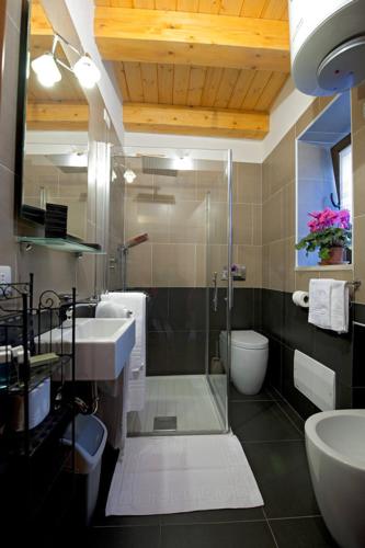 a bathroom with a shower and a sink and a toilet at Le Case Dello Zodiaco albergo diffuso in Modica