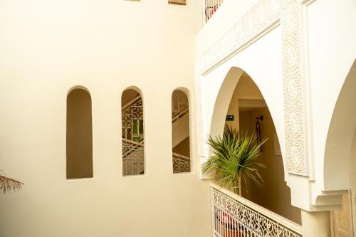 a hallway of a building with arches and a plant at Riad JAIA in Marrakesh