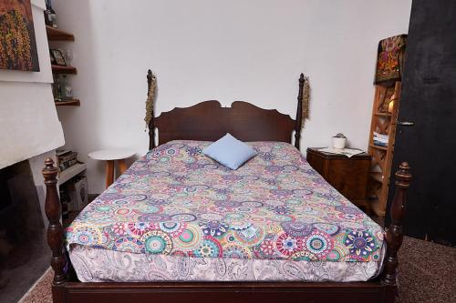 a bedroom with a bed with a blue pillow on it at Rio Holístico Escapada de Bienestar y relax para Parejas o duplas in Ramallo