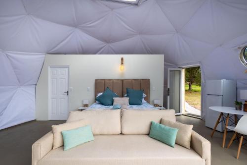 a living room with a bed and a couch at Five Elements Resort - Dome Glamping Tent in Harkerville