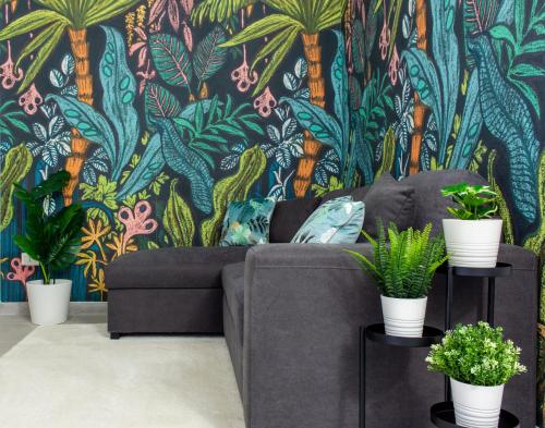 a living room with a couch and a tropical wallpaper at Tropical Boutique Apartment in Gallipoli