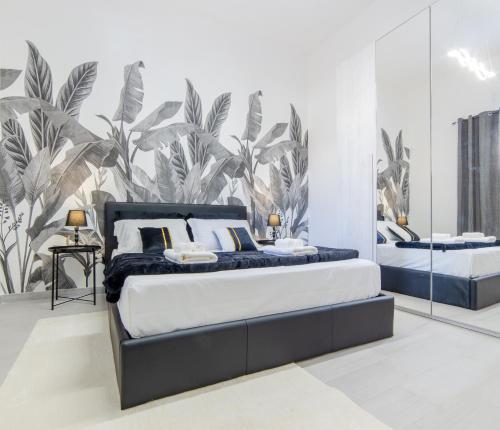a bedroom with two beds and a mural of plants at Tropical Boutique Apartment in Gallipoli