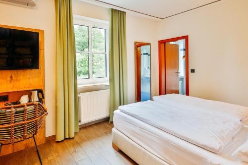 a bedroom with a large white bed and a window at Landhotel Kauzenberg in Bad Kreuznach