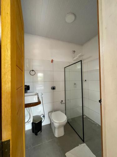 a bathroom with a toilet and a sink at Vila Pimenta Rosa in Caraíva