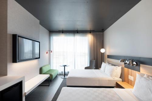 a hotel room with a bed and a tv at Alt Hotel Calgary University District in Calgary