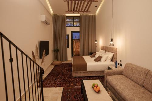 a bedroom with a bed and a couch and a table at DUNIA Desert Suites in Mitzpe Ramon