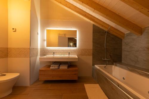 a bathroom with a sink and a tub and a mirror at Alojamientos La Antigua in Molina de Aragón