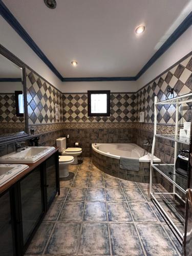 a bathroom with two sinks and a tub and a toilet at Chalet vacacional con piscina privada in Arriate