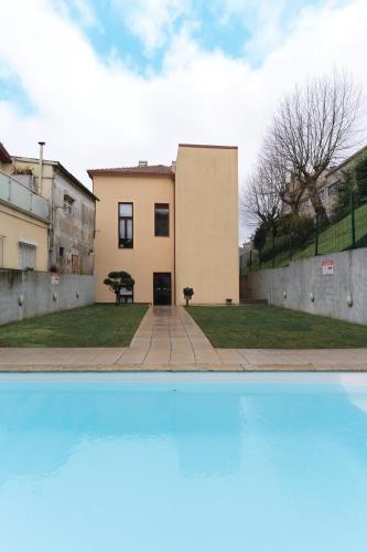 a house with a pool in front of a building at Douro by your side with Pool in Vila Nova de Gaia