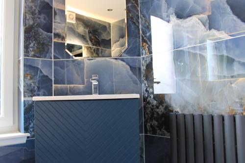 a bathroom with a sink and blue tiles at Edinburgh West Luxury 5 Bedroom Home in Edinburgh