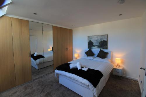 a bedroom with a large bed and a mirror at Edinburgh West Luxury 5 Bedroom Home in Edinburgh