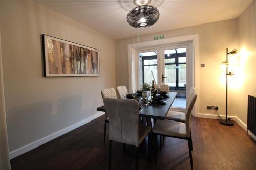 a dining room with a table and chairs at Edinburgh West Luxury 5 Bedroom Home in Edinburgh
