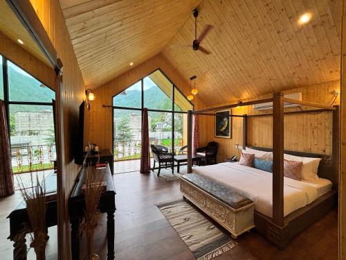 ein Schlafzimmer mit einem Bett in einem Zimmer mit Fenstern in der Unterkunft Celestial Dream in Uttarkāshi