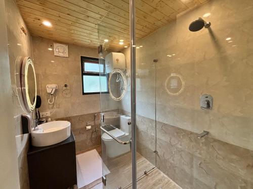 ein Badezimmer mit Toilette, Waschbecken und Dusche in der Unterkunft Celestial Dream in Uttarkāshi