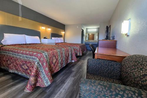 a hotel room with two beds and a desk at Eagle Inn by Hotel O Richmond Midlothian Turnpike in Richmond