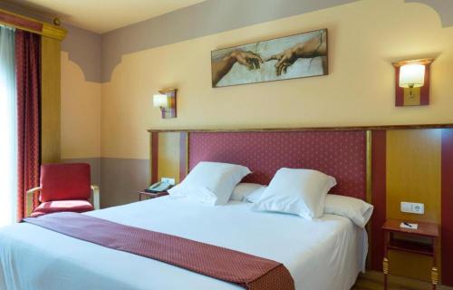 a bedroom with a large white bed and a red chair at Hotel Fuente Las Piedras in Cabra