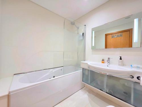 a white bathroom with a tub and a sink at Spacious Summer Fresh Family Apartment with Panoramic Sea Views in Funchal in Funchal
